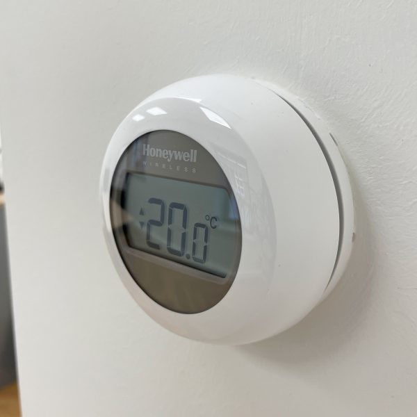 Een digitale thermometer aan de muur gemonteerd.
