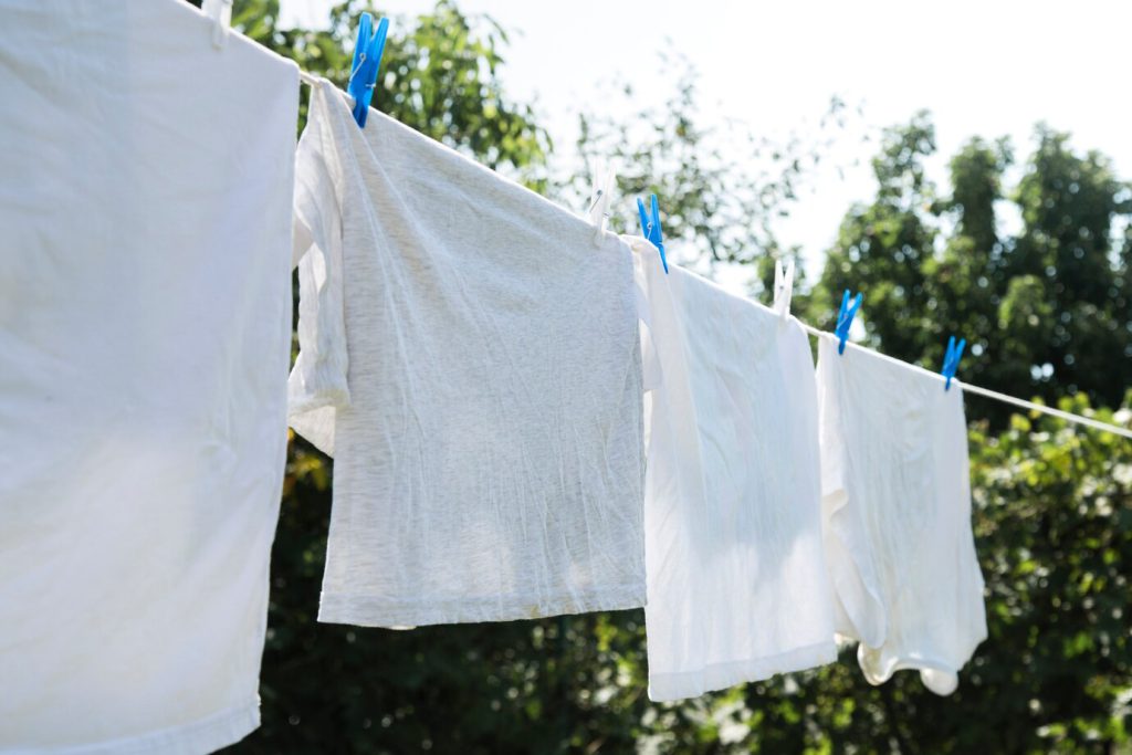 Witte t-shirts die aan een waslijn hangen.