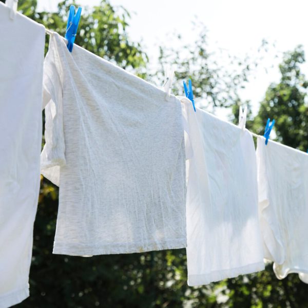 Witte t-shirts die aan een waslijn hangen.